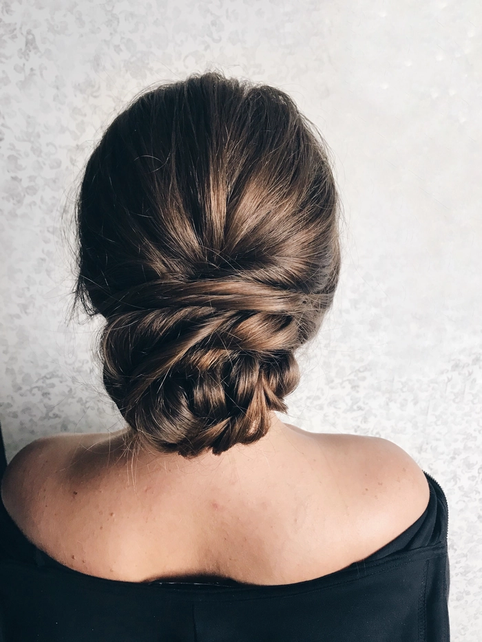 Sophisticated twisted low bun hairstyle perfect for weddings and special occasions Elegant wedding hair twisted low bun adorned with delicate floral accents