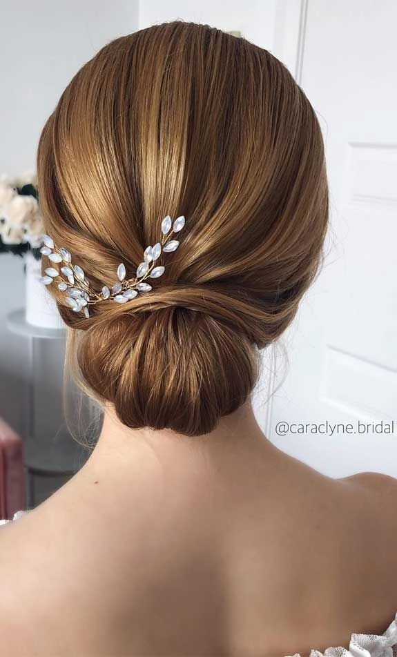 Beautifully styled twisted low bun for stunning bridal look Elegant wedding hair twisted low bun with delicate accessories
