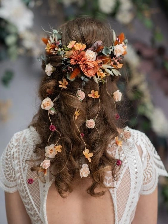 Elegant fall autumn wedding hair adorned with colorful leaves for a romantic bridal look