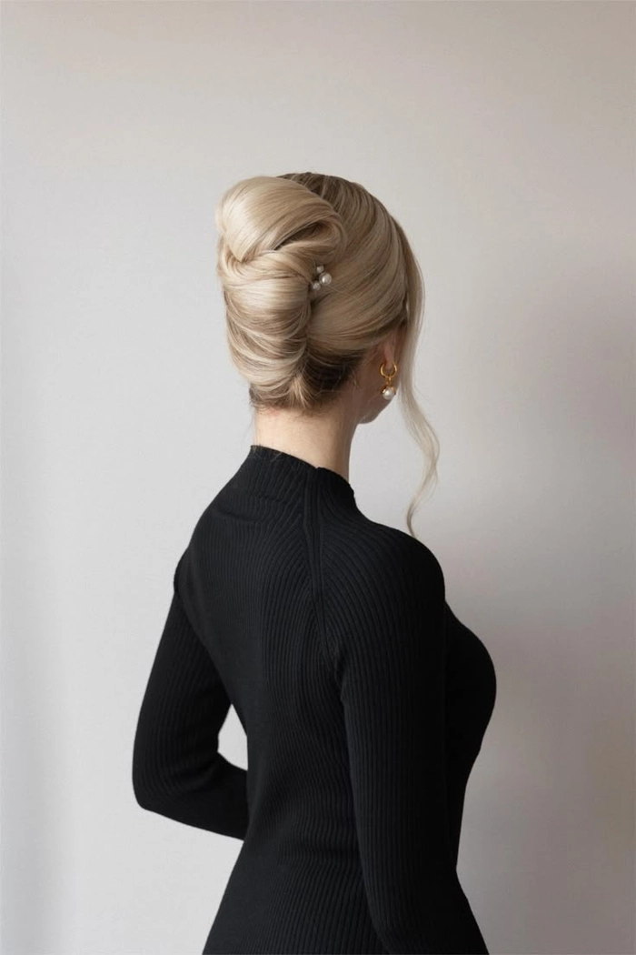 Elegant French twist bridal hair styled with delicate floral accents for a sophisticated wedding look