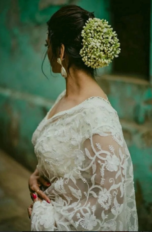 Elegant wedding hairstyle featuring a classic Indian bridal look with gajra adornment Traditional Indian bridal hair styled elegantly with white gajra flowers