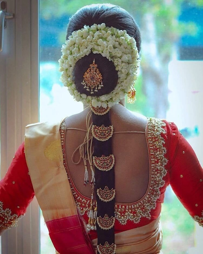 Elegant wedding hair design featuring gajra for a classic Indian bride Traditional Indian bridal hairstyle adorned with white jasmine gajra flowers