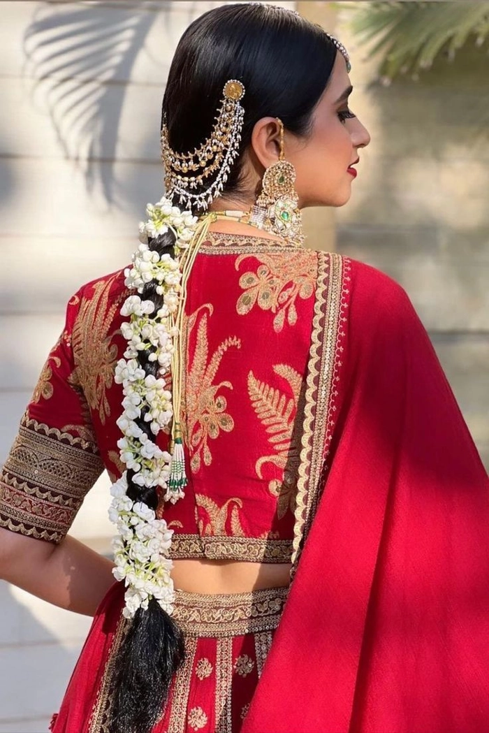 Elegant wedding look featuring a classic Indian bride with gajra in her hair Traditional Indian bridal hairstyle adorned with fresh jasmine gajra flowers