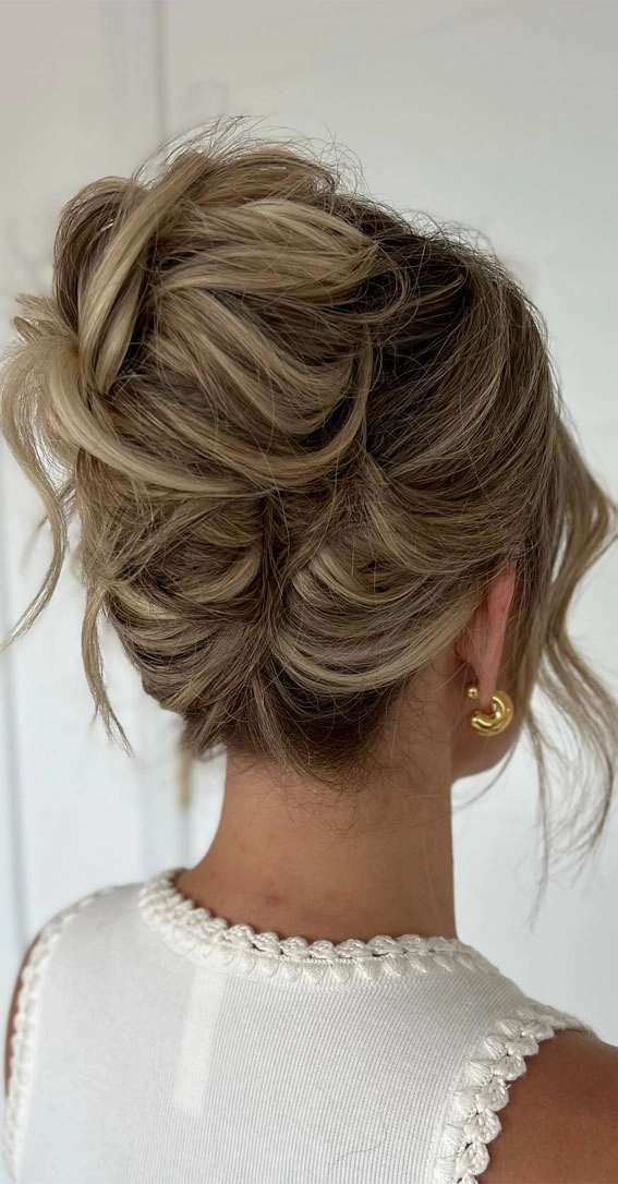 Elegant low updo perfect for a relaxed bridal look in wedding hairstyles gallery 4 Messy textured low bridal updo hairstyle with loose tendrils and soft waves