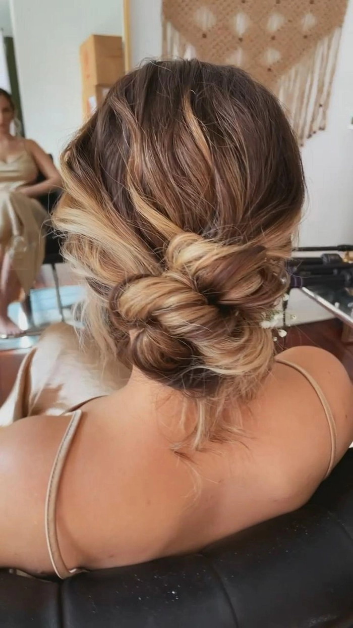 Elegant messy textured low bridal updo perfect for a romantic wedding look Messy textured low bridal updo hairstyle with loose strands and soft volume