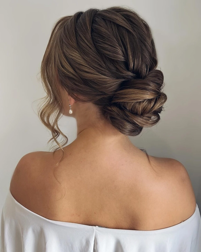 Elegant wedding hairstyle featuring a textured low bun perfect for brides Messy textured low bridal updo hairstyle with loose waves and soft tendrils