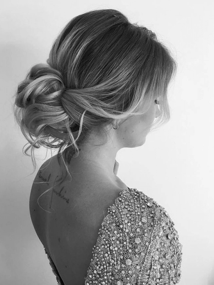 Elegant low updo hairstyle perfect for brides wanting a natural, textured look Bride with a messy textured low bridal updo showcasing an elegant wedding hairstyle