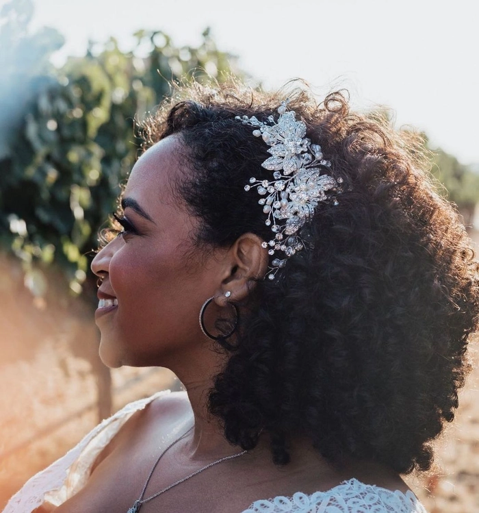 Elegant natural black hair bridal look with soft curls and floral accents