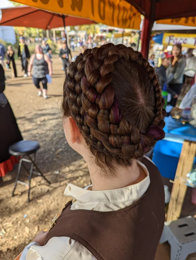 Beautiful bridal hairstyle perfect for a renaissance fair themed wedding celebration Elegant renaissance fair wedding hair styled with intricate braids and floral accents