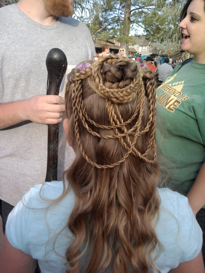 Elegant bridal hairstyle perfect for a renaissance fair themed wedding ceremony Romantic renaissance fair wedding hair styled with braids and floral accents