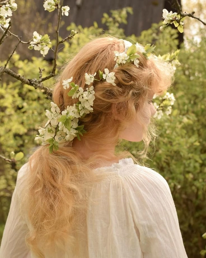 Soft romantic cottagecore wedding hair style with loose curls and floral accessories