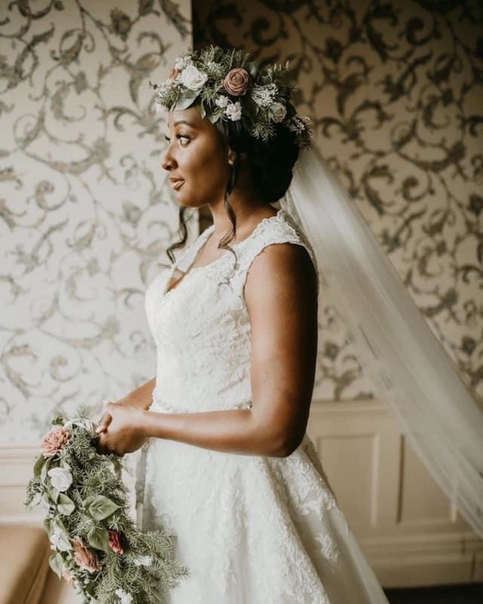 Outdoor rustic wedding bridal hair styled with loose braids and floral accents