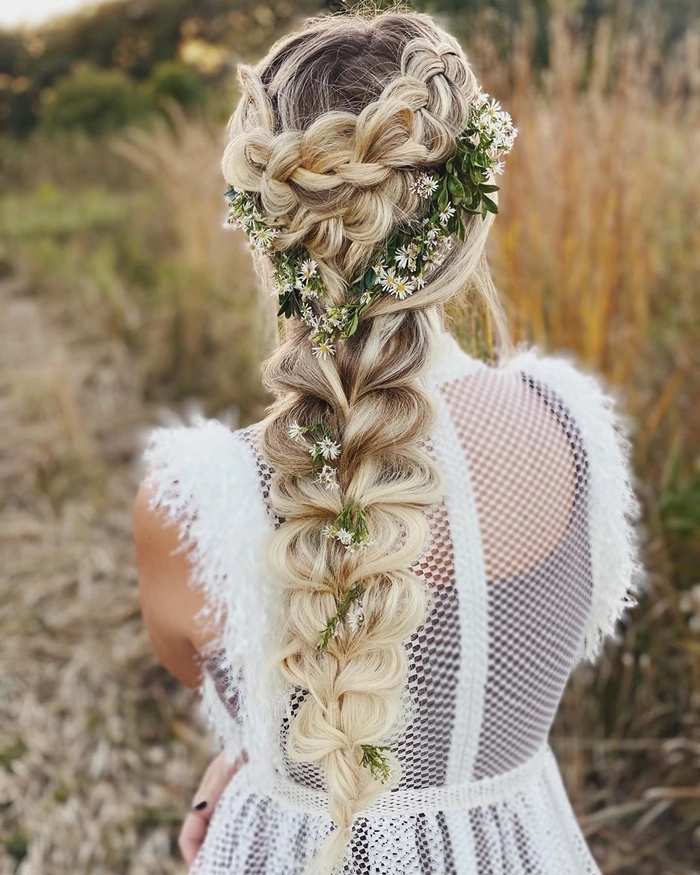 Elegant outdoor rustic wedding bridal hair styled with soft waves and floral accents