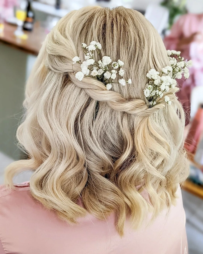 Shoulder length wedding hair styled half up with delicate floral accessories