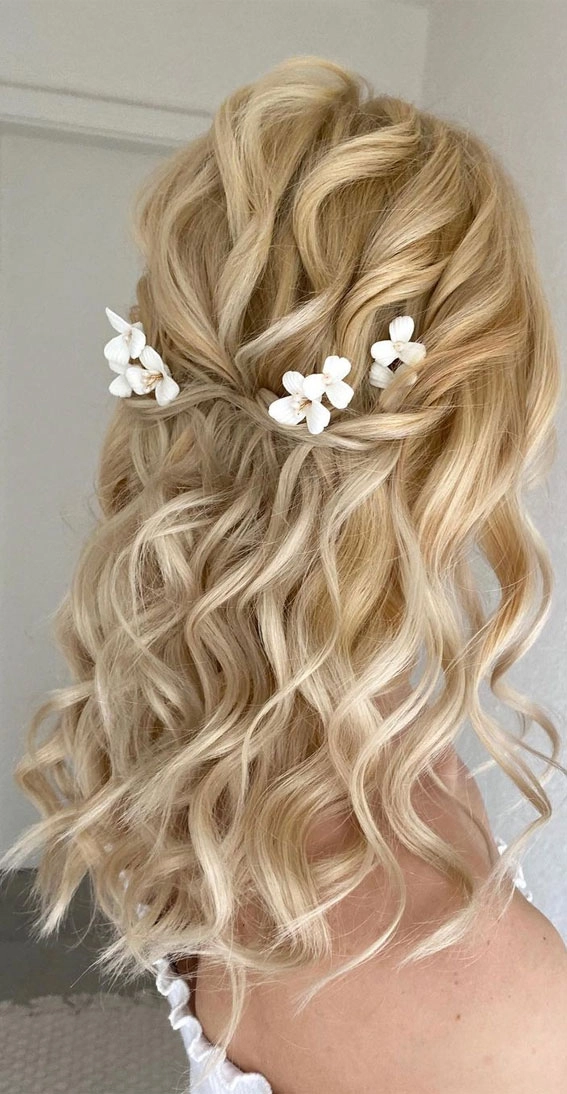 Shoulder length wedding hair styled half up with soft curls and delicate floral accents