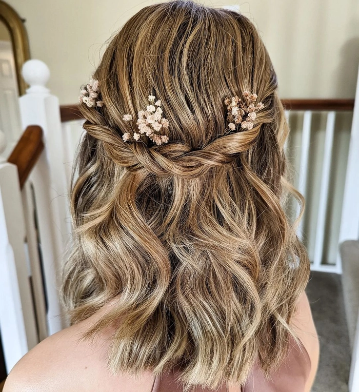 Shoulder length wedding hair styled half up with soft curls and floral accessories