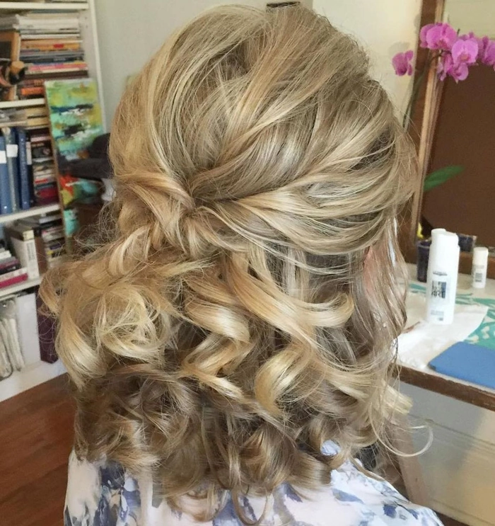 Shoulder length wedding hair styled half up with soft curls and delicate floral accents
