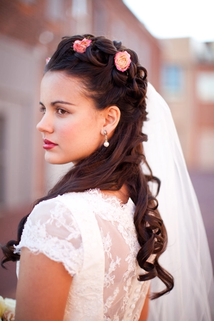 Elegant Victorian era inspired bridal hair with intricate curls and floral accents