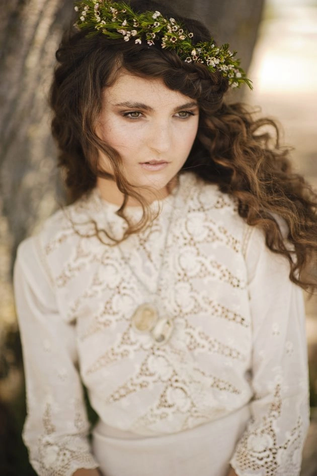 Victorian era inspired bridal hair styled with delicate curls and floral accents