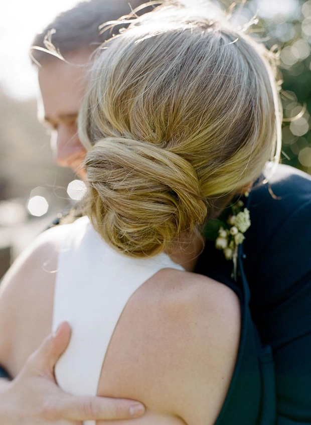 Stunning bridal hairstyle featuring a classic knot updo for weddings Elegant wedding hair knot updo with delicate floral accents