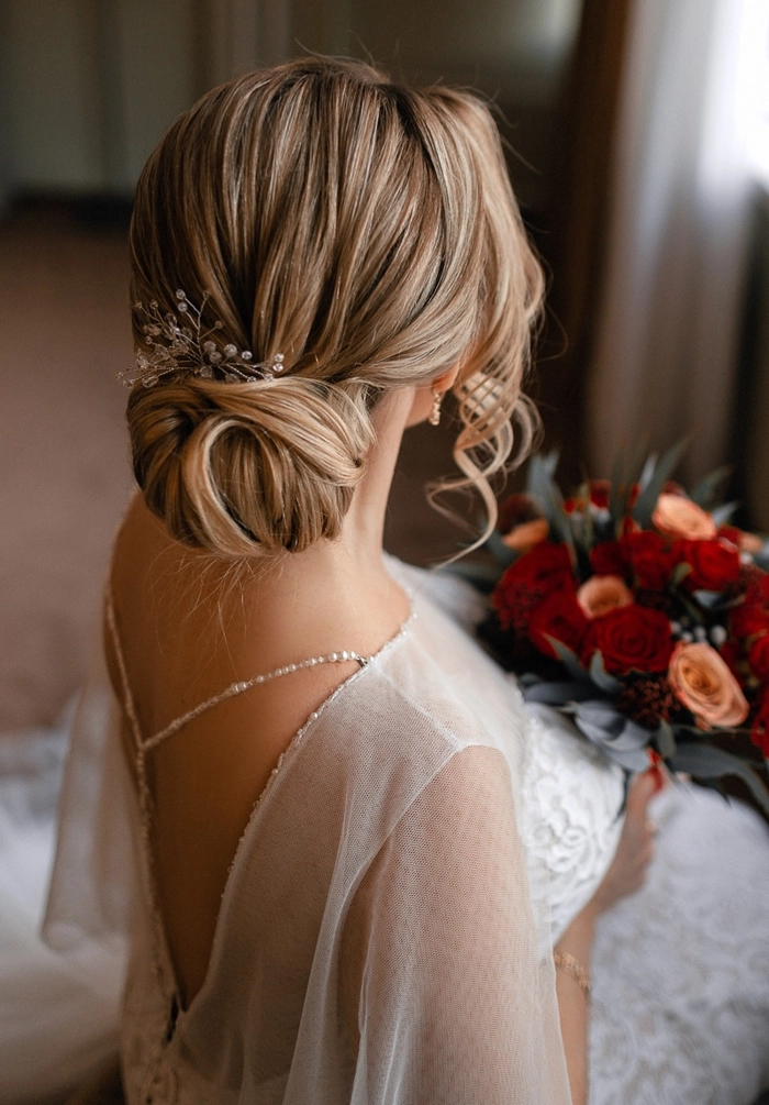 Chic and timeless twisted low bun hairstyle for brides on their wedding day Elegant wedding hair twisted low bun with delicate floral accessories