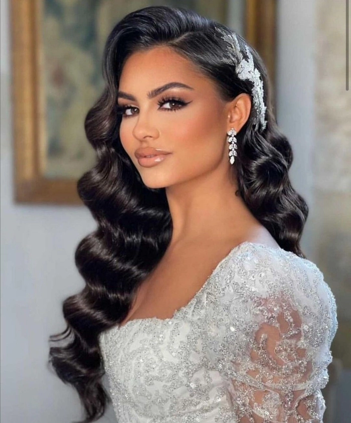 Elegant big hair wedding style with voluminous curls and floral accessories
