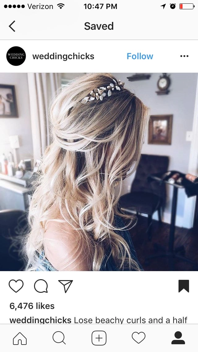 Elegant wedding hairstyle for blonde balayage featuring soft curls and floral accents