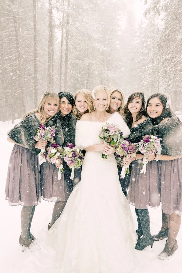 Bride showcasing winter wedding hair with elegant faux fur accessories in a snowy setting