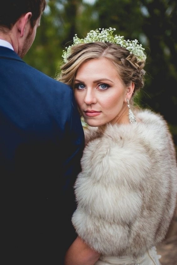 Bride showcasing elegant winter wedding hair with faux fur accessories in soft curls