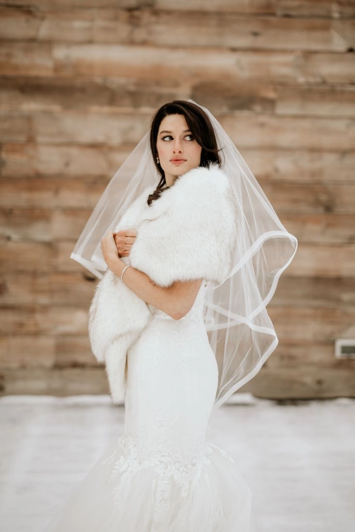 Elegant winter wedding hairstyle adorned with delicate faux fur hairpieces
