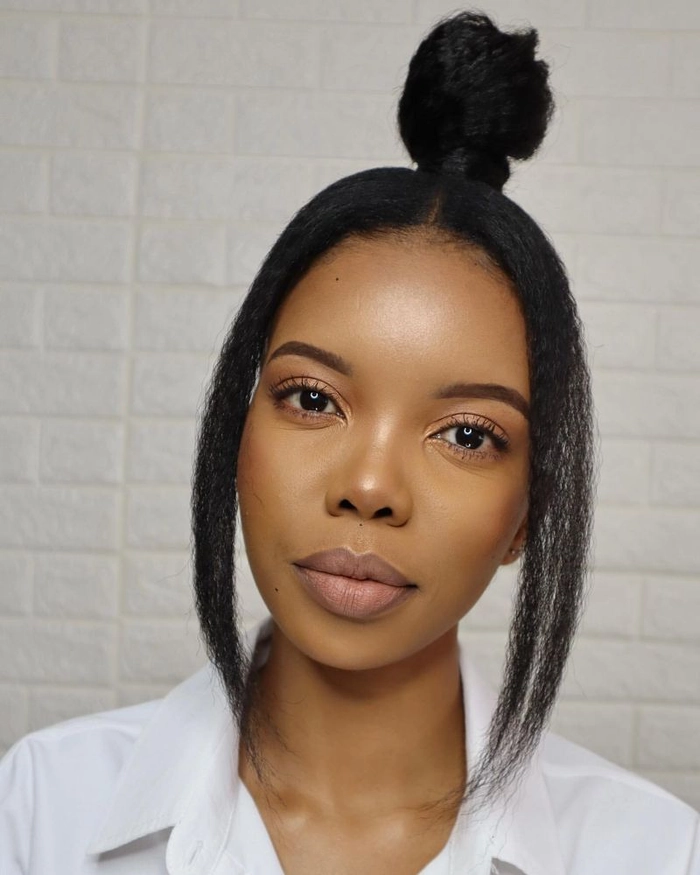 A polished top knot with subtle texture and a soft side swoop, perfect for business casual settings