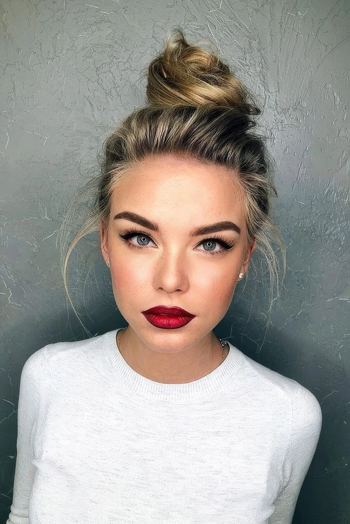 Elegant messy top knot hairstyle with soft face-framing pieces for a business casual look