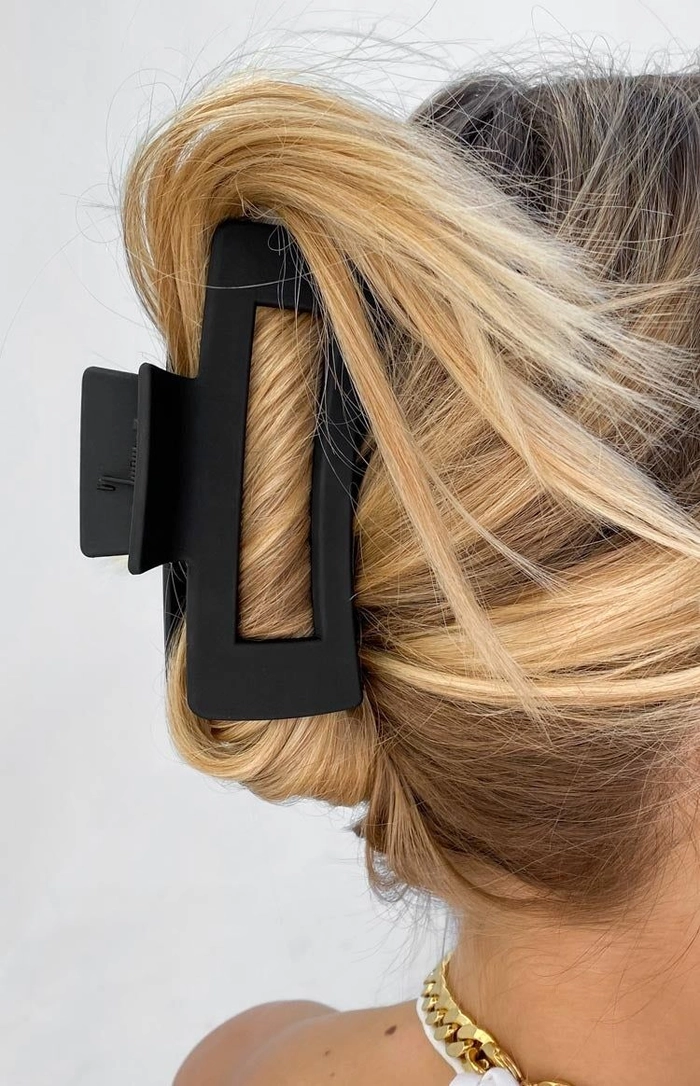Comparison of medium vs large claw clips securing thick work hair in a tidy low bun
