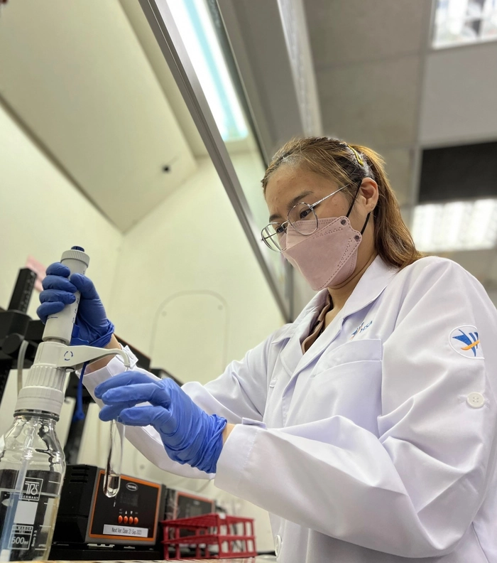 Laboratory technician wearing a surgical cap over a low bun for complete hair containment