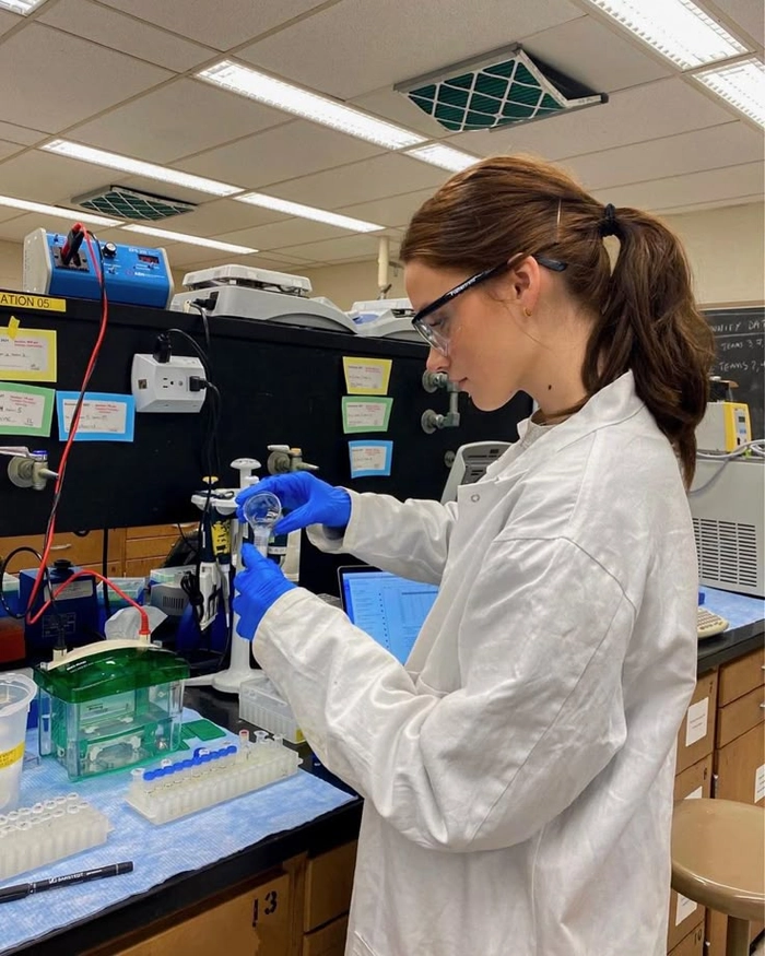 Lab technician with a low bun secured under a hairnet for full containment