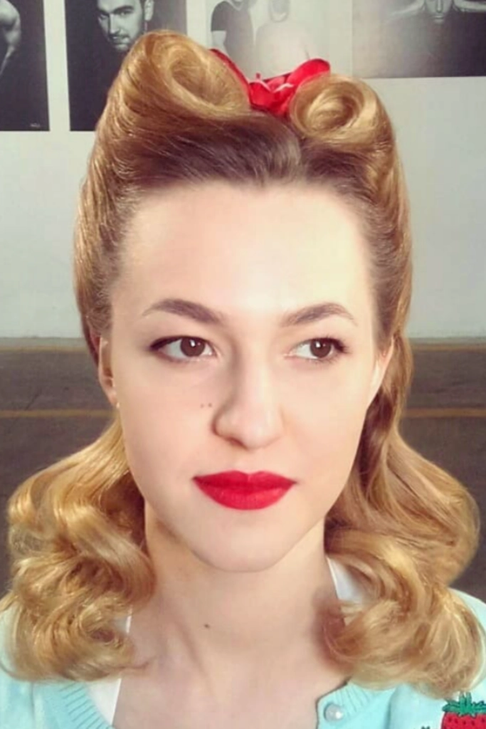 Woman showcasing rolled vintage victory rolls hairstyle suitable for retro themed work events