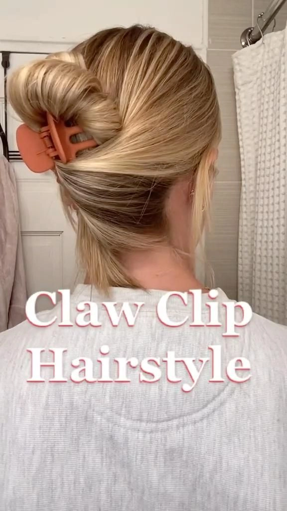 Woman with a sleek claw clip updo for corporate casual Friday, her hair twisted and pinned neatly at the back of her head with a tortoiseshell clip, wearing a blazer and blouse.