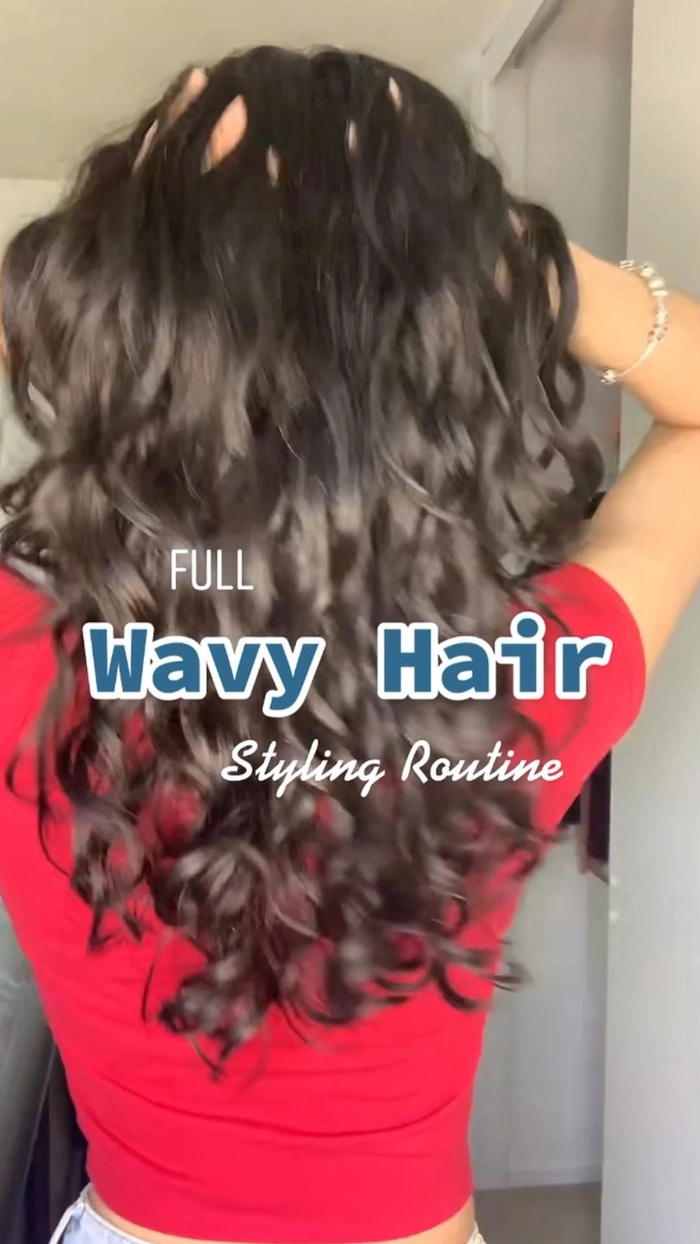 Professional woman with wavy hair secured in a low bun using a silk scarf at her office desk