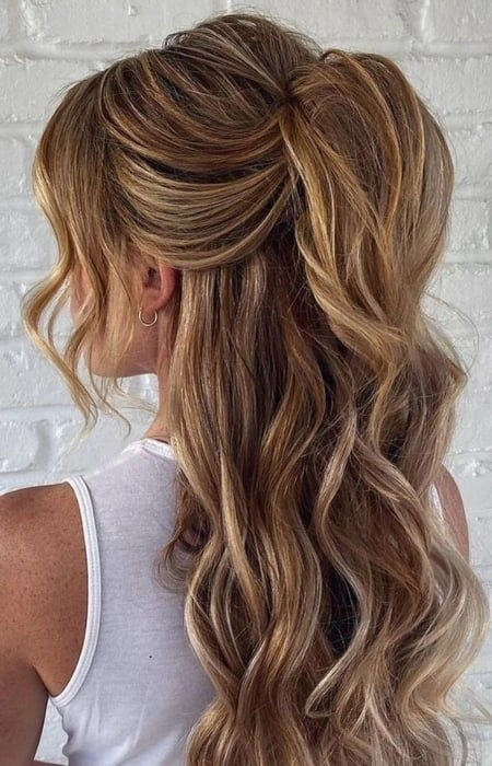 Minimalist half up half down work hairstyle with a sleek low bun and soft waves