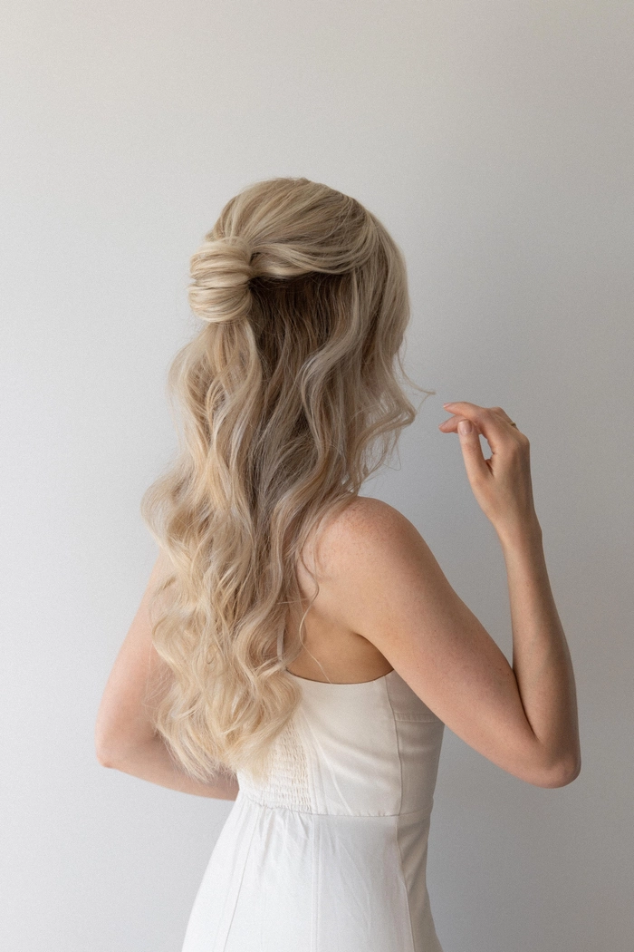 A woman with a minimalist half up half down hairstyle in a professional office setting