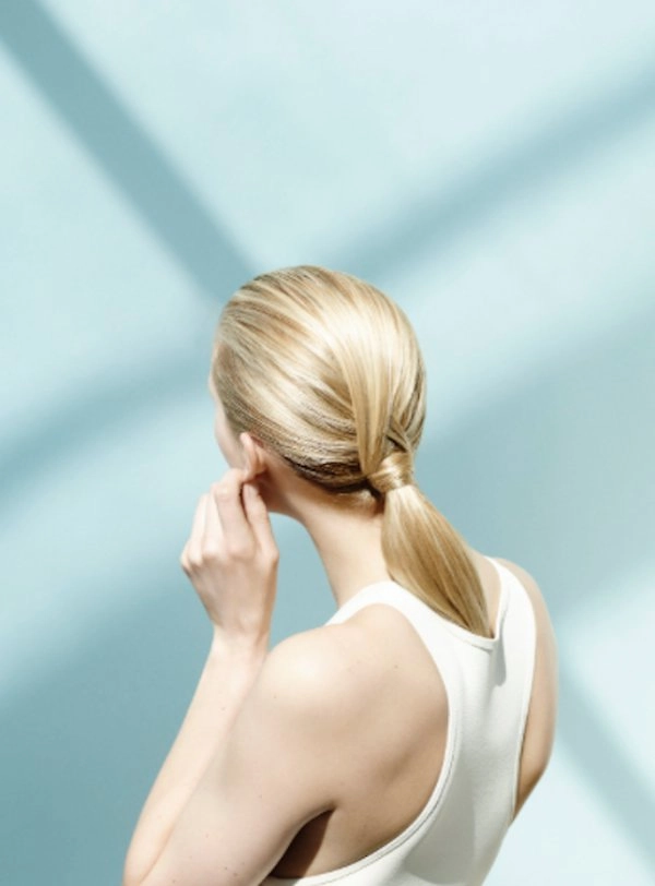 sleek knotted low ponytail hairstyle for minimalist office wear
