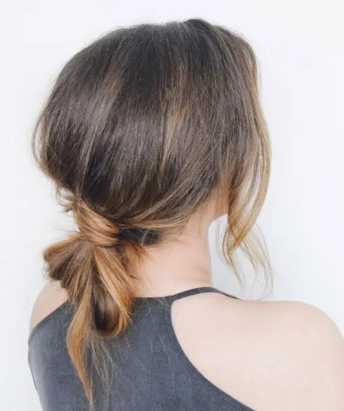 Sleek knotted low ponytail hairstyle for a minimalist office look