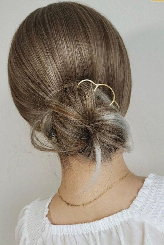 Minimalist hairpin placements for a sleek office bun with clean lines
