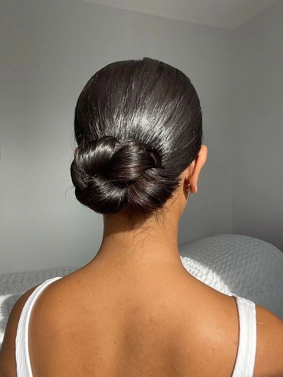 Minimalist hairpin placements creating a sleek office bun with a polished finish