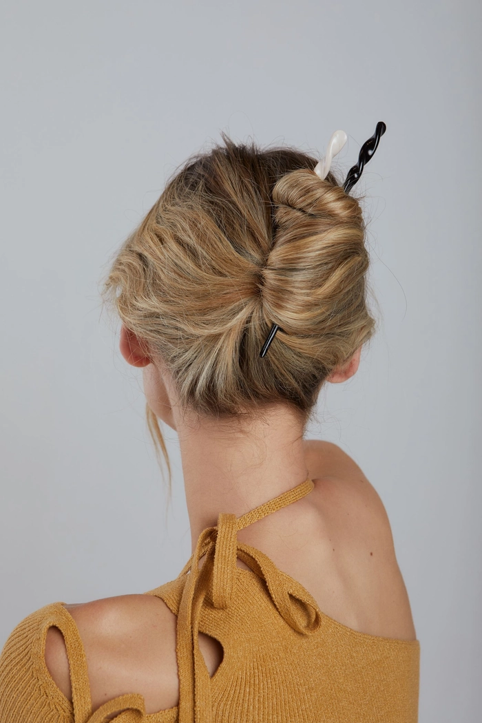 Minimalist hairpin placements securing a sleek office bun