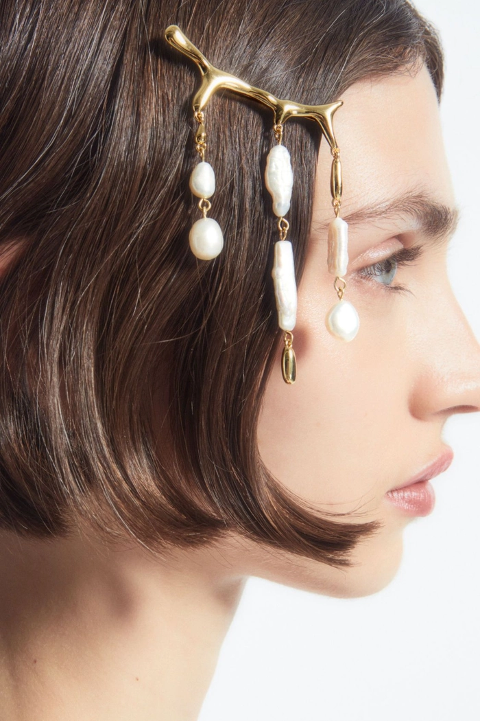 Pearl hair clip arrangement in a sleek corporate updo for professional presentations