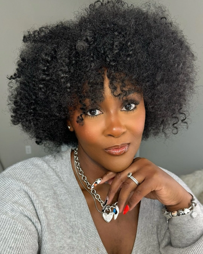 Professional woman with a polished twist out hairstyle in a corporate office setting