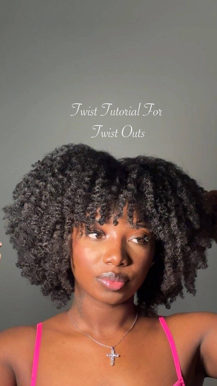 A professional woman with neat, defined twist-out curls styled for a polished corporate look, paired with a tailored blazer and minimal accessories.
