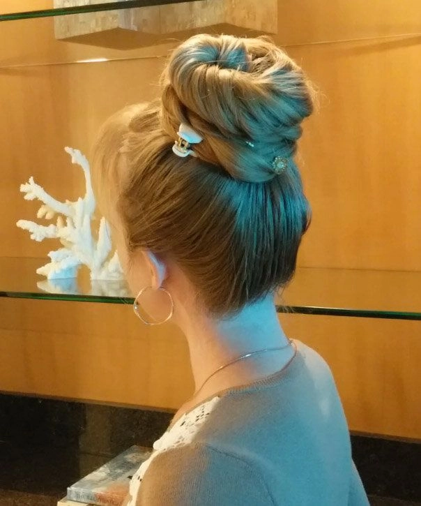 How to create a secure work bun for very long waist-length hair A woman with waist-length hair styled in a secure low bun for professional work