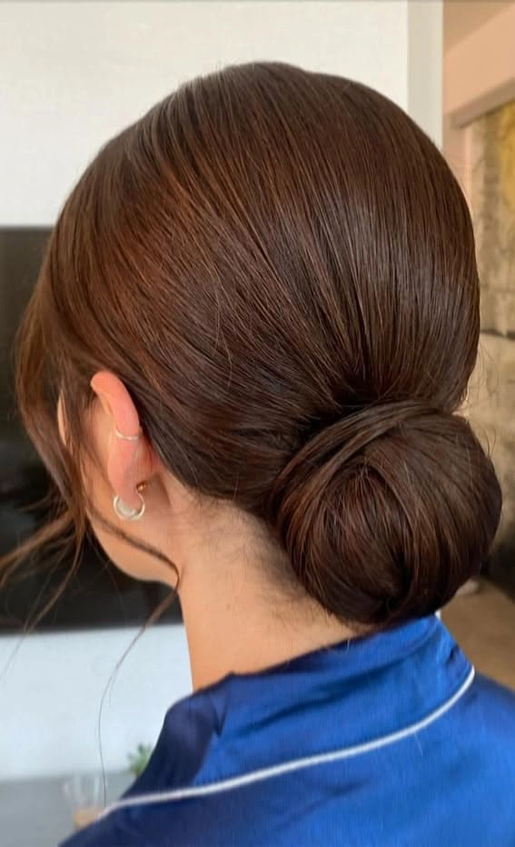 Professional low bun with center part suitable for corporate settings Sleek middle part low bun hairstyle for executive presentations